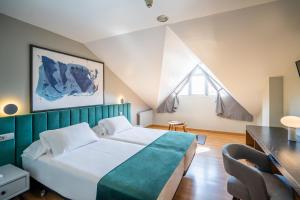 Un dormitorio con una cama grande y una ventana. en Abba Comillas Hotel, en Comillas 37 fotos más