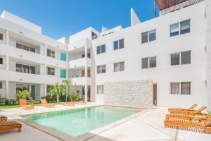 una piscina di fronte a un edificio bianco di Penthouse Apartments Private Roof Pool 200m to Beach a Chicxulub