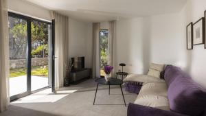 a living room with a purple couch and a tv at Mare Solis Pinea in Mali Lošinj