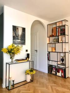a living room with a book shelf with books at LuxeLevallois chic stay with balcony 800 meters from Paris in Levallois-Perret