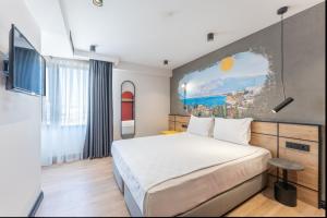 una camera d'albergo con un letto e un dipinto sul muro di Just Inn City 