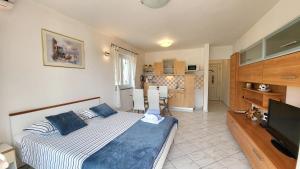 ein Schlafzimmer mit großem Bett und eine Küche in der Unterkunft Apartmani Agava in Čižići + 19 Fotos