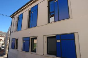 a building with blue doors on the side of it at EL BAILE, casa con jacuzzi al lado de Peñafiel in Olmos de Peñafiel