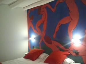 ein Schlafzimmer mit einer Wand mit einem Gemälde darauf in der Unterkunft EL BAILE, casa con jacuzzi al lado de Peñafiel in Olmos de Peñafiel