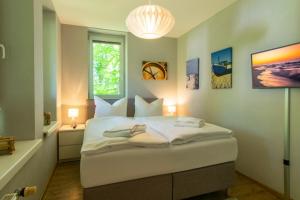 - une chambre avec un grand lit blanc et une fenêtre dans l'établissement Strand-Park Strand-Park 113, à Heringsdorf