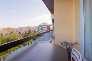 a balcony with a table and a view of a city at Lodging Apartments Guell Gaudi in Barcelona