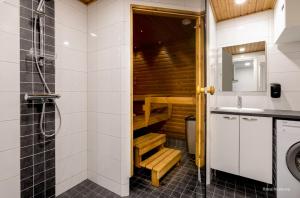 La salle de bains est pourvue d'une douche et d'un lavabo. dans l'établissement Holiday Club Saariselkä Apartments, à Saariselka