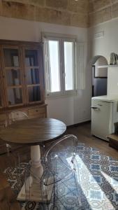 a kitchen with a table and a refrigerator at Dimora Del Sorriso in Monopoli