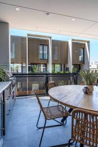 an open kitchen and dining room with a table and chairs at SYLO Luxury Apartments - 1Gb Fibre Internet in Adelaide
