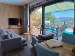 sala de estar con mesa, sillas y TV en Panoramic Residences Bodrum en Bodrum