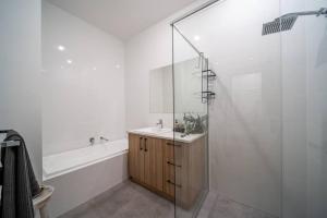 a bathroom with a shower and a sink and a tub at SYLO Luxury Apartments - 1Gb Fibre Internet in Adelaide +37 photos
