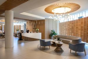 a lobby with a couch and chairs and a counter at NissiBlu Beach Resort in Ayia Napa