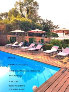 a deck with chairs and umbrellas next to a swimming pool at Hotel Villa Maya in Saint-Tropez