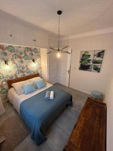 a bedroom with a large bed with a blue blanket at 2 pièces au centre d'Antibes. in Antibes