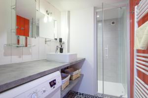 y baño con lavabo y ducha. en Appart le Grignon, en Saint-Martin-de-Ré