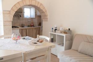 uma sala de estar com uma mesa e uma cozinha em Trullo Dimora Zaccaria em Alberobello