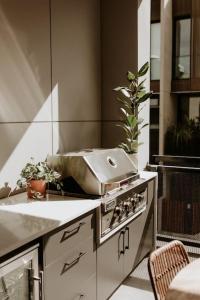 a kitchen with a stove with a pot on it at SYLO Luxury Apartments - LVL 2 in Adelaide