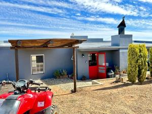 a red motorcycle parked in front of a house at Groenvlei Cottage in Porterville