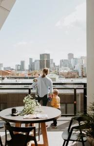 une femme et un enfant debout sur un balcon dans l'établissement SYLO Luxury Apartments - Penthouse LVL 3, à Adélaïde