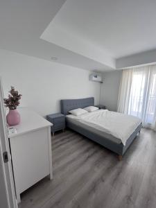 a bedroom with a bed and a table and a window at Cosmopolis Bliss: Your Home Away from Home in Ştefăneştii de Jos