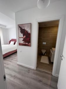a room with a bed and a bathroom with a toilet at Cosmopolis Bliss: Your Home Away from Home in Ştefăneştii de Jos