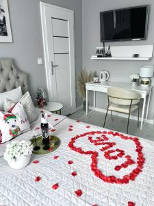 維斯瓦的住宿－Pokoje Marilyn Monroe，一张床上有红色玫瑰花瓣的床