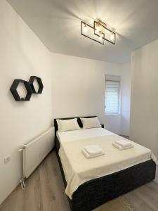 ein Schlafzimmer mit einem Bett mit zwei Handtüchern darauf in der Unterkunft Hexagon Apartment in Temerin
