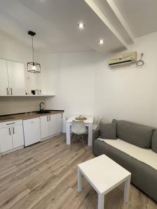 uma sala de estar com um sofá e uma mesa em Hexagon Apartment em Temerin