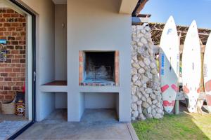 a fireplace in the side of a house with surfboards at Beach Breakaway Apartment in Langebaan