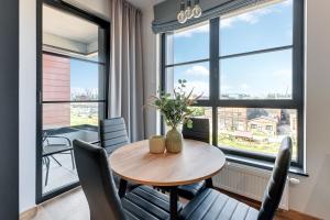 a dining room with a table and chairs and a large window at Downtown Apartments DOKI Living & Foodhall in Gdańsk