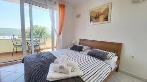 ein Schlafzimmer mit einem Bett mit Handtüchern darauf in der Unterkunft Apartmani Agava in Čižići