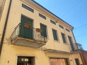 a building with a balcony and a window at Sunny house in SantʼAmbrogio di Valpolicella