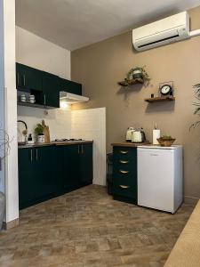 a kitchen with green cabinets and a white refrigerator at Apartments Dent in Umag