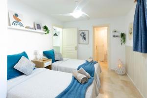 Dos camas en una habitación con azul y blanco. en Serenity Arenas - Caleta de Fuste, en Caleta de Fuste 22 fotos más