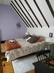 a bedroom with a bed with pillows on it at La Maison des Fleurs in Scrignac