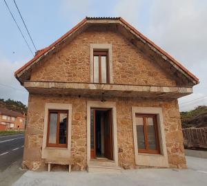 a small brick building on the side of a street at Casa Rojo in Camariñas