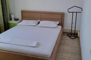 a bed with white sheets and a lamp in a room at MaraM in Constanţa
