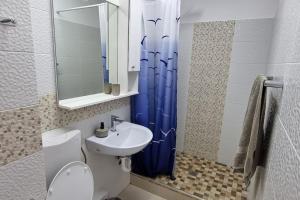 a bathroom with a blue shower curtain and a sink at MaraM in Constanţa