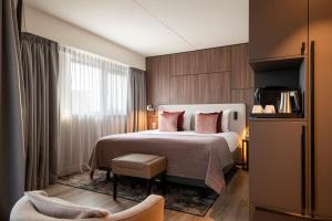 ein Hotelzimmer mit einem Bett und einem Stuhl in der Unterkunft Bilderberg Europa Hotel Scheveningen in Scheveningen