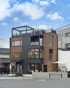 a brick building with a balcony on top of it at Mont-モン-KAMOGAWA STAY and HOTEL in Kyoto