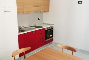 a kitchen with red cabinets and a table and chairs at HOTEL HOUSE GARGANO in San Giovanni Rotondo +93 photos
