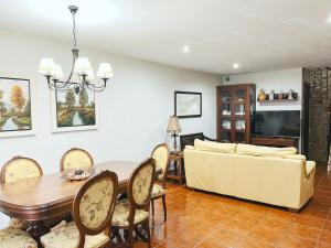 sala de estar con sofá, mesa y sillas en CASA CASTAÑEIRA, en Combarro