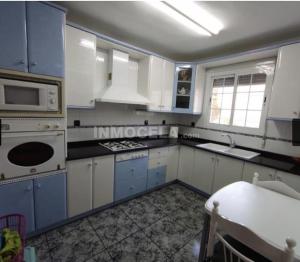 a kitchen with white cabinets and a stove top oven at Casa La Torre de la Balsa de Cela 