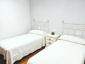 Habitación con 3 camas y mesita de noche con 2 camas en CASA CASTAÑEIRA, en Combarro