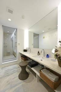 a bathroom with a sink and a large mirror at Mont-モン-KAMOGAWA STAY and HOTEL in Kyoto
