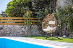 a rattan chair sitting next to a swimming pool at Villa Meri in Gabonjin