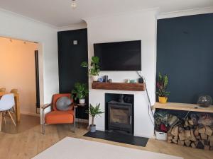 a living room with a fireplace and a flat screen tv at Spacious Unique Brighton Home FREE Parking in Brighton & Hove