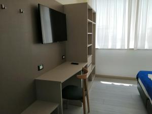 a small room with a desk and a bed at HOTEL HOUSE GARGANO in San Giovanni Rotondo