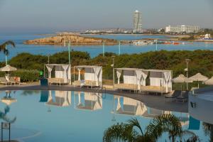 a hotel swimming pool with a view of the ocean at NissiBlu Beach Resort in Ayia Napa