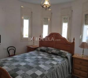 a bedroom with a bed with a checkered blanket on it at Casa La Torre de la Balsa de Cela 